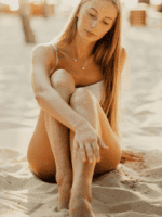 depilacja laserowa ruda śląska kobieta siedzi na piasku o zachodzie słońca