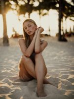 depilacja laserowa ruda śląska kobieta siedzi na piasku o zachodzie słońca